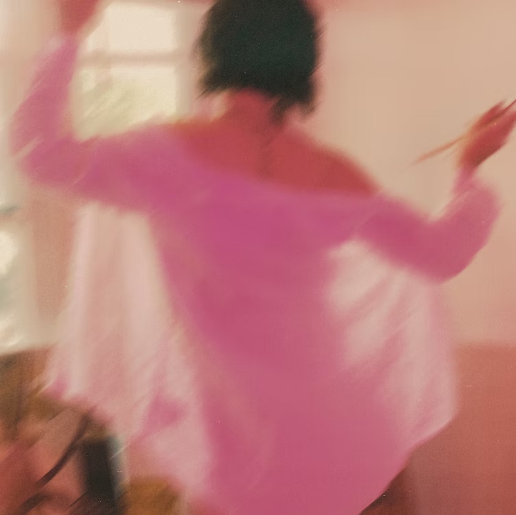 A sunlit moment in motion, wearing a pink shirt